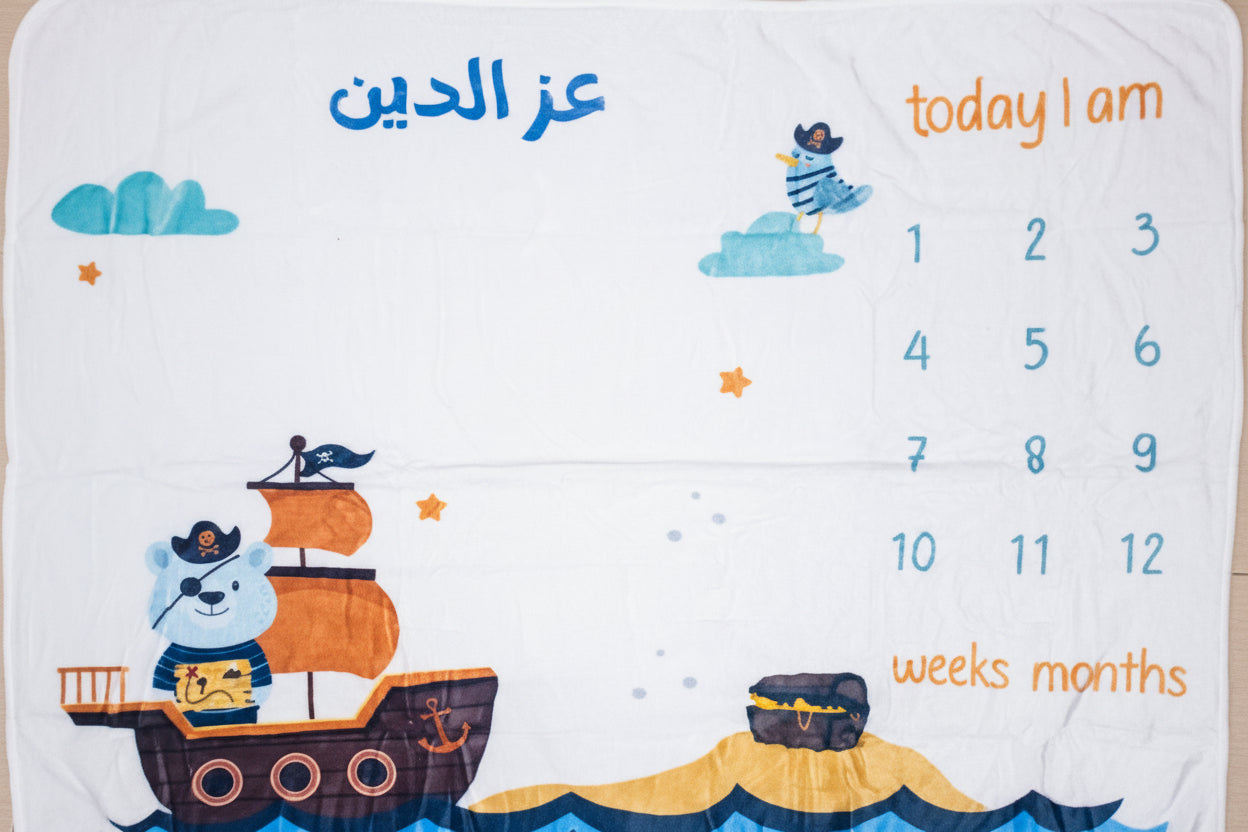 Baby milestone mat with ship design on a tiled floor